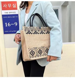 Close-up of ethnic linen tote bag featuring black geometric patterns and woven rope handles