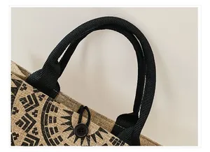 Detalle del bolso tote de yute con asas negras reforzadas y cierre de botón