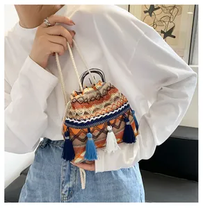 Détail d'un sac seau bohème à cordon avec motifs tissés colorés et pampilles à franges