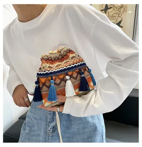 Détail du sac seau bohème avec motifs géométriques orange et glands en soie colorés