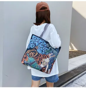 Modella che porta una grande borsa tote in arazzo con stampa floreale pittura a olio