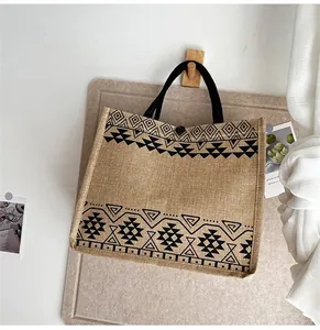 Detailed close-up of ethnic linen tote bag with geometric tribal print and black handles
