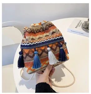 Gros plan du sac seau tissé bohème avec des motifs géométriques colorés et des glands