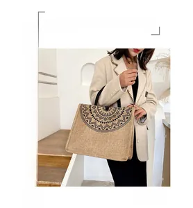 Detail of printed geometric pattern on natural burlap tote bag with black top handles