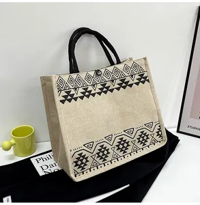 Detail of burlap tote bag with black geometric tribal prints and woven rope handles