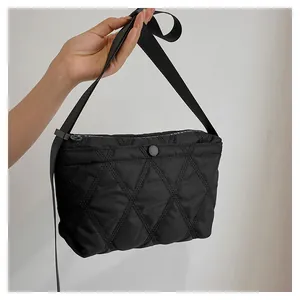 Detail of black quilted shoulder bag with white Forever Young print and nylon fabric