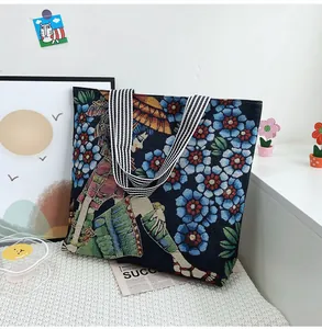 Dettaglio della trama jacquard tessuta e del ricamo floreale sulla borsa a tracolla