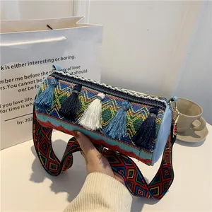 Ethnic blue cylinder crossbody bag with tassel detail and wide embroidered strap