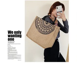 Detalle de bolso tote de lino con diseño de mandala negro y asas redondas negras