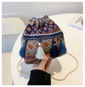 Détail d'un sac seau tissé avec glands colorés, cordon de serrage et bandoulière