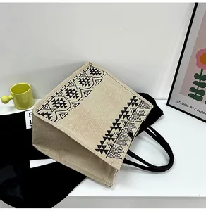 Detail of jute tote bag showing ethnic geometric prints and black woven handles
