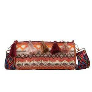 Bohemian woven cylinder crossbody bag with colorful tassels and wide geometric strap