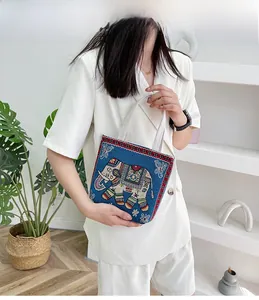 Borsa etnica in tela blu navy con ricamo a forma di elefante colorato e manici bianchi