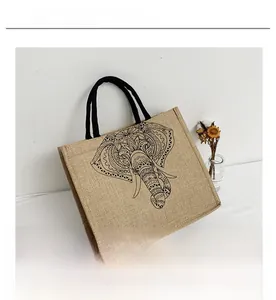 Detailed view of bohemian elephant print on natural linen tote bag with black handles