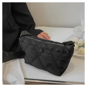 Detail of black quilted dumpling bag with Forever Young text on woven strap