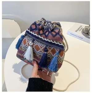 Détail du sac seau bohème tissé coloré avec pompons et cordons de serrage tressés