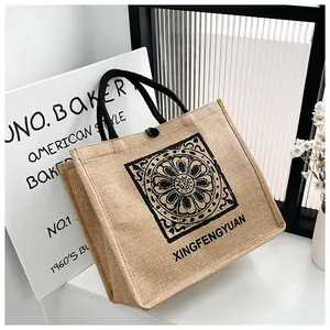 Close-up of linen tote bag featuring a vintage floral mandala print and woven handles