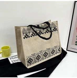Detailed view of the woven jute fabric texture and black ethnic geometric print on a tote bag