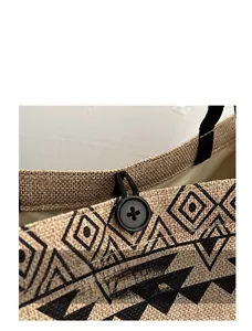 Detail view of the button closure and elastic strap on a geometric canvas tote bag
