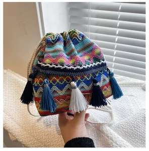 Détail du sac seau bohème tissé avec des motifs colorés et des glands de coton