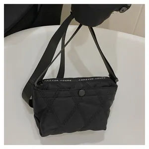 Detail of black quilted crossbody bag with Forever Young letter strap and round buckle