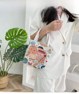 Dettaglio di una borsa in tela con ricami colorati a forma di elefante e fiori