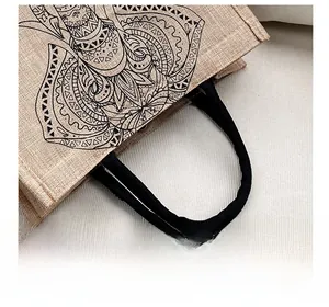 Detail showing the reinforced black strap and natural jute fiber texture of the elephant bag
