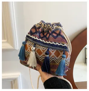 Vue détaillée d'un sac seau bohème coloré avec motifs tissés à la main et pompons