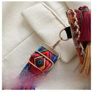 Close-up of golden metal buckle with colorful ethnic woven strap and tassel details