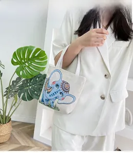 Foto lifestyle di una borsa in lino ricamata etnica con motivo a elefante blu stilizzato