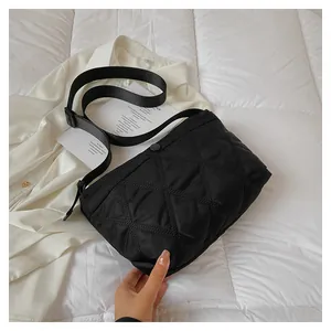 Close-up of black quilted dumpling bag with adjustable strap and matte finish details