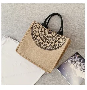 Primer plano de bolso de lino con diseño de mandala negro y cierre de botón decorativo