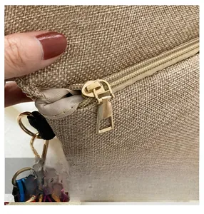 Detail showing smooth gold metal zipper and ethnic woven strap on canvas bag