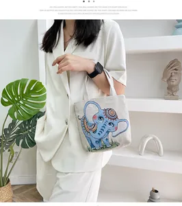 Dettaglio della borsa in tela con motivo a elefante ricamato e trama in tessuto beige