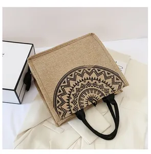 Detalle del bolso tote de yute bohemio con estampado geométrico y cierre de botón