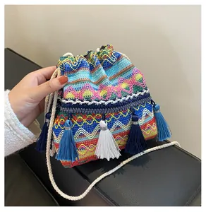 Détail d'un sac seau bohème tissé coloré avec des glands et une bandoulière en coton doux