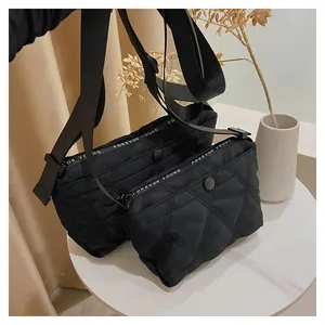 Detail of black quilted shoulder bags with Forever Young strap on a white table