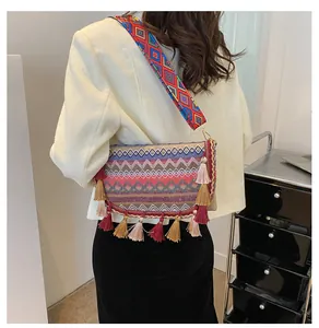 Close-up of colorful ethnic woven crossbody bag with vibrant fringe and geometric strap