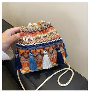 Détail du sac seau bohème à cordon avec tissage géométrique coloré et franges