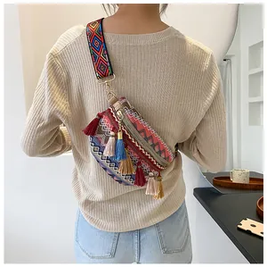 Close-up of bohemian ethnic sling bag featuring colorful tassels and geometric strap