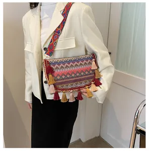 Ethnic style woven crossbody bag with colorful geometric patterns and long tassels on the side