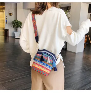 Dettaglio della borsa a secchiello boho con ricami geometrici colorati e lunghe nappe a strati