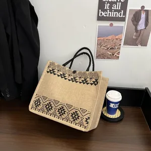 Detail of bohemian jute tote bag featuring black geometric ethnic patterns on natural linen