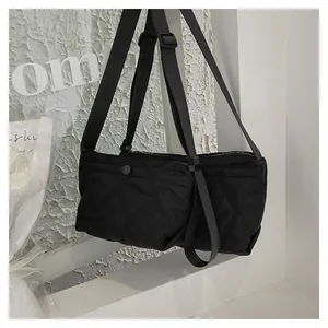 Detail of black quilted shoulder bag with Forever Young text and wide adjustable strap
