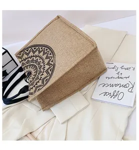 Detalle del bolso tote de yute con estampado de mandala y asas negras en blazer
