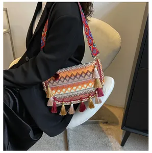 Detailed view of bohemian crossbody bag with colorful wavy textures and fringe tassels