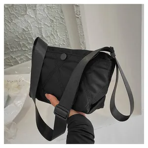 Detail of black quilted cloud bag showing soft padded nylon texture and snap closure