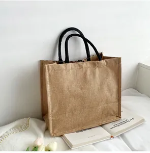 Gros plan d'un sac shopping en jute avec anses tressées noires et texture naturelle