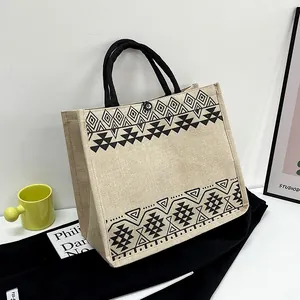 Ethnic printed linen tote bag with geometric patterns and black braided handles