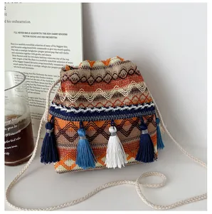 Détails rapprochés d'un sac seau bohème tissé avec des pompons et des motifs colorés